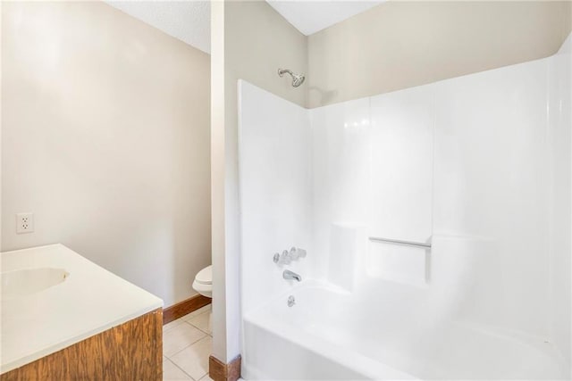 bathroom featuring tile patterned flooring, vanity, toilet, baseboards, and shower / bathing tub combination
