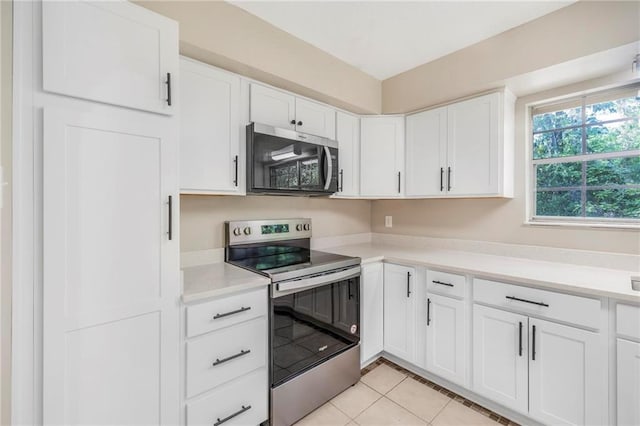 kitchen with light countertops, white cabinets, appliances with stainless steel finishes, and light tile patterned floors