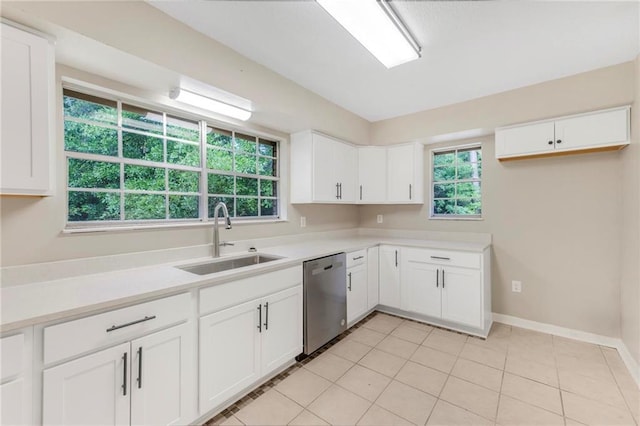 kitchen featuring stainless steel dishwasher, baseboards, light countertops, white cabinetry, and a sink