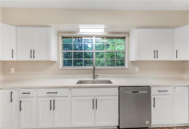 kitchen with a sink, light countertops, stainless steel dishwasher, and white cabinetry