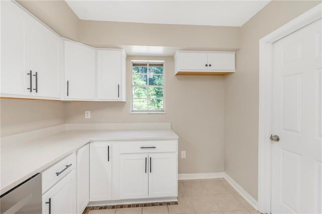 kitchen featuring light countertops, baseboards, white cabinets, and light tile patterned flooring