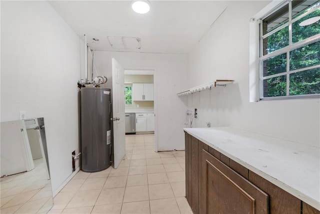 clothes washing area with laundry area, light tile patterned floors, and electric water heater