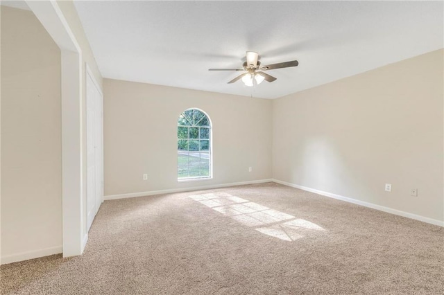 empty room featuring carpet floors, baseboards, and a ceiling fan