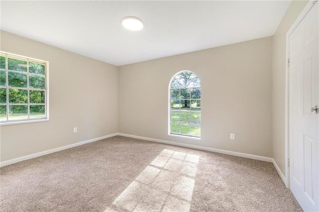 unfurnished room featuring carpet floors and baseboards
