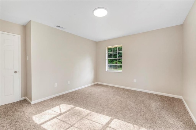 unfurnished room with carpet flooring, baseboards, and visible vents