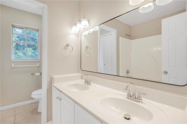 full bath featuring a sink, tile patterned flooring, toilet, and double vanity