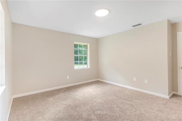 unfurnished room with baseboards, visible vents, and carpet