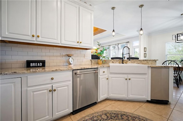 kitchen featuring dishwasher, white cabinets, hanging light fixtures, and plenty of natural light