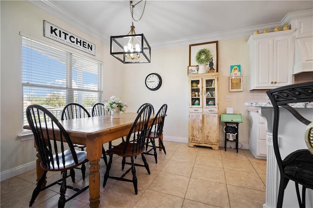 tiled dining area featuring a notable chandelier and ornamental molding