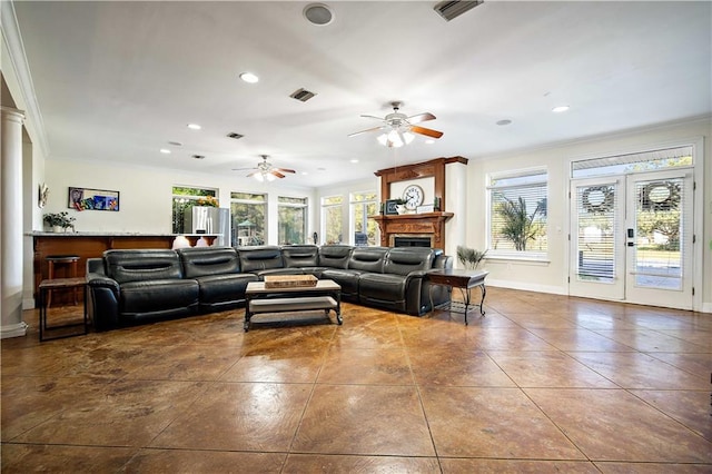 living room with a fireplace, a wealth of natural light, crown molding, and ceiling fan