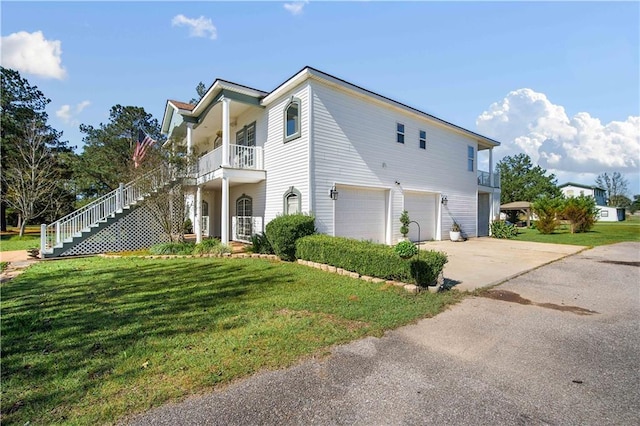 view of side of home with covered porch, a yard, and a garage