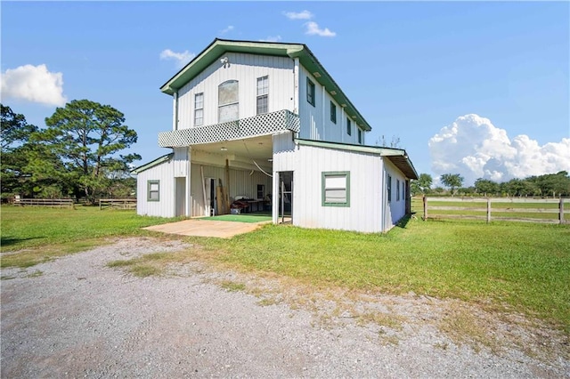 back of property featuring a yard and an outdoor structure