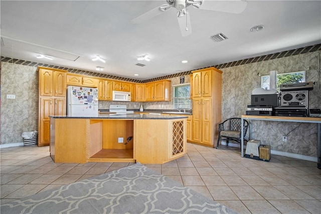 kitchen with ceiling fan, light tile patterned floors, a kitchen island, and white appliances