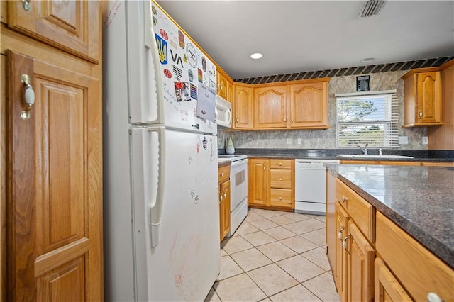 kitchen featuring tasteful backsplash, sink, light tile patterned floors, and white appliances