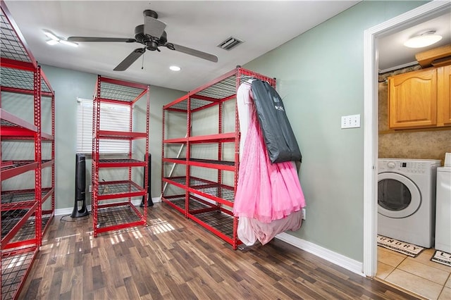 clothes washing area featuring washing machine and dryer, cabinets, ceiling fan, and wood-type flooring