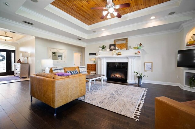 living room featuring ceiling fan, dark wood-type flooring, a tray ceiling, wood ceiling, and ornamental molding