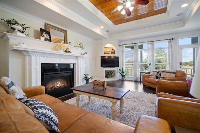 living room featuring hardwood / wood-style floors, ornamental molding, and a tray ceiling