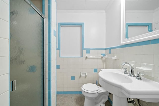 bathroom with crown molding, sink, tile walls, toilet, and a shower with shower door