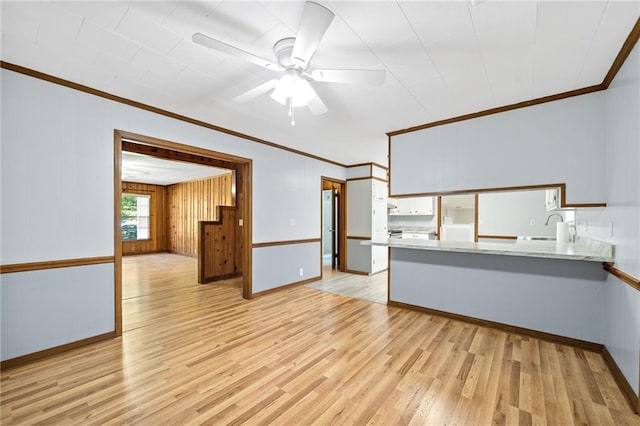 unfurnished living room with ceiling fan, crown molding, sink, and light hardwood / wood-style flooring