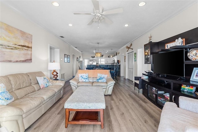 living area featuring recessed lighting, ceiling fan, light wood finished floors, and ornamental molding