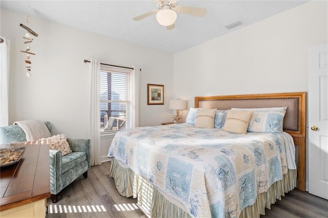 bedroom featuring wood finished floors, visible vents, and a ceiling fan