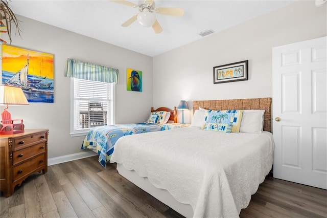 bedroom featuring baseboards, a ceiling fan, wood finished floors, and visible vents