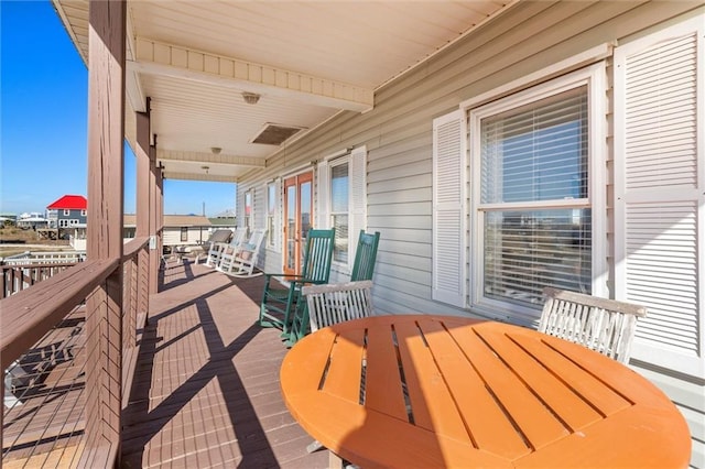 wooden terrace featuring outdoor dining area and french doors