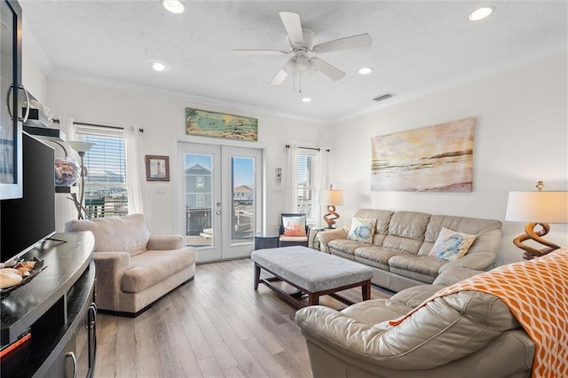 living area with light wood-type flooring, visible vents, recessed lighting, a ceiling fan, and crown molding