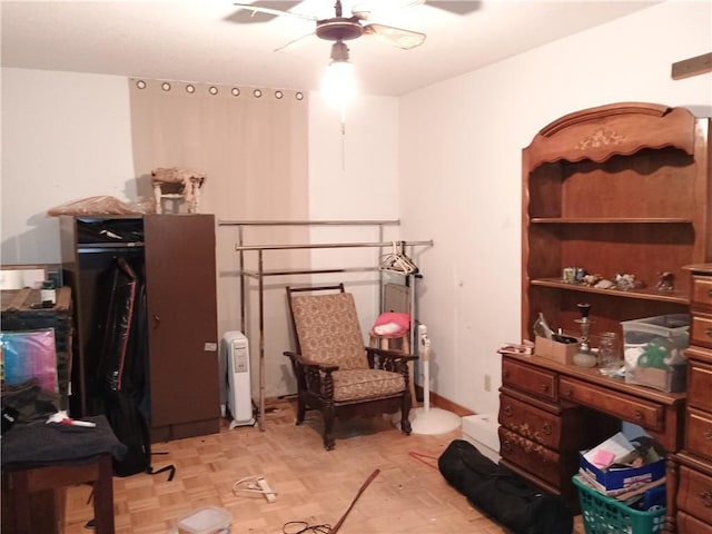 sitting room featuring ceiling fan and light parquet floors