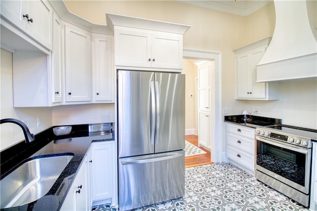 211 Cedar St, Mobile, AL 36602 - kitchen featuring stainless steel appliances, custom range hood, white cabinets, dark stone counters, and crown molding