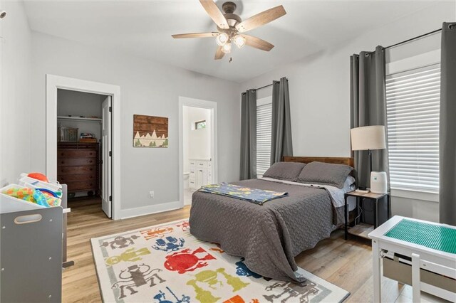3699 Elysian Fields Dr, Saraland, AL 36571 - bedroom with light wood-type flooring, a spacious closet, baseboards, and multiple windows