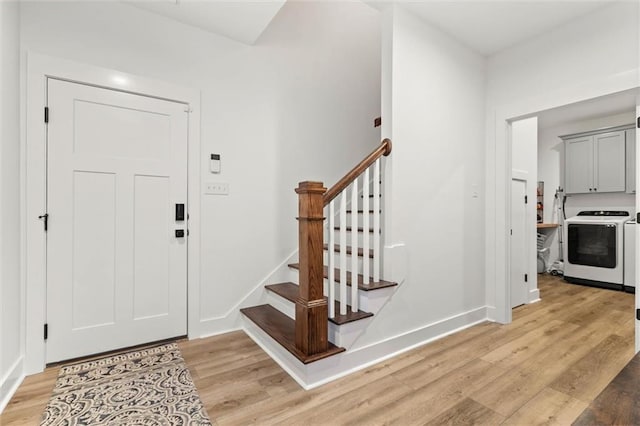 3699 Elysian Fields Dr, Saraland, AL 36571 - foyer entrance featuring washer and clothes dryer, light wood-style floors, stairway, and baseboards