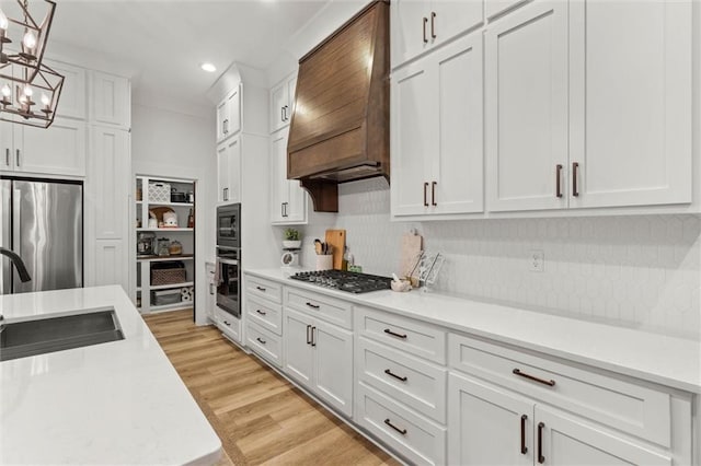 3699 Elysian Fields Dr, Saraland, AL 36571 - kitchen with stainless steel appliances, a sink, light countertops, white cabinetry, and premium range hood