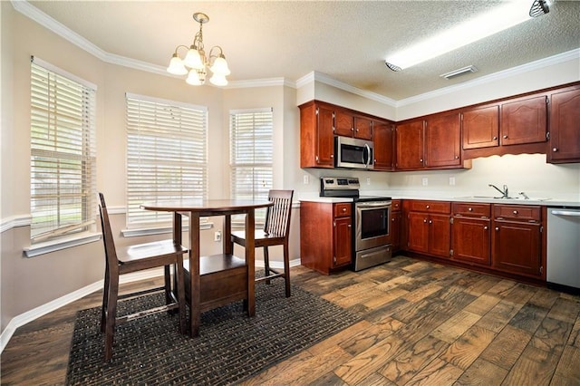 kitchen featuring crown molding, a textured ceiling, decorative light fixtures, dark hardwood / wood-style flooring, and stainless steel appliances