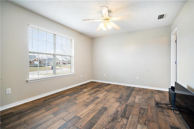 empty room with a textured ceiling, ceiling fan, and dark wood-type flooring