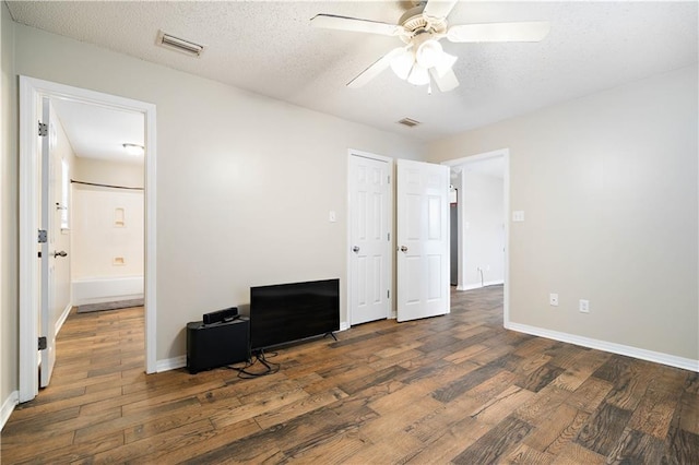 bedroom featuring a textured ceiling, ceiling fan, and dark wood-type flooring