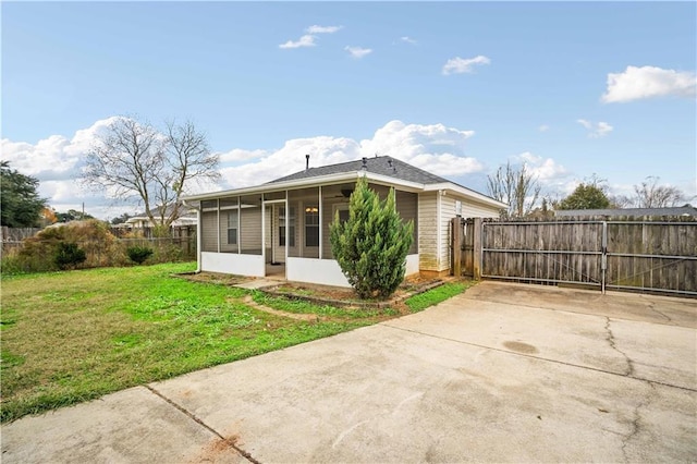 rear view of property with a yard and a sunroom