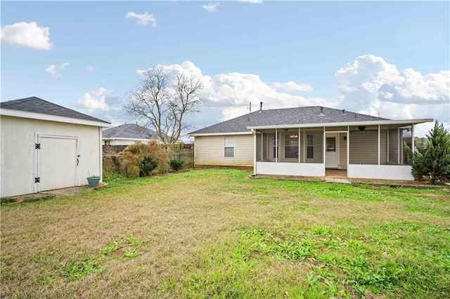 back of property with a yard and a sunroom