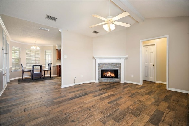 living room with dark wood-type flooring, lofted ceiling with beams, ceiling fan with notable chandelier, ornamental molding, and a fireplace