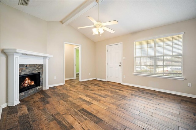 unfurnished living room with dark hardwood / wood-style flooring, lofted ceiling with beams, a stone fireplace, and ceiling fan