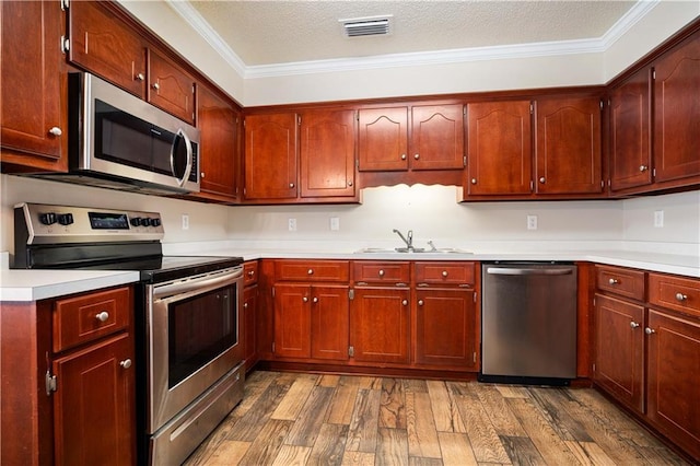 kitchen featuring crown molding, sink, stainless steel appliances, and dark hardwood / wood-style floors