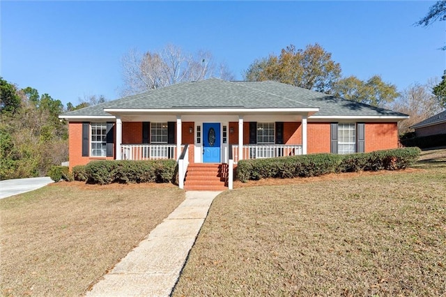 ranch-style house featuring brick siding, covered porch, and a front yard