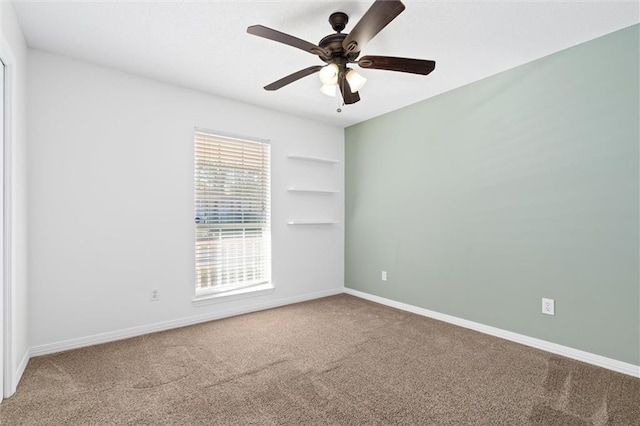 unfurnished room with built in features, carpet, baseboards, and ceiling fan