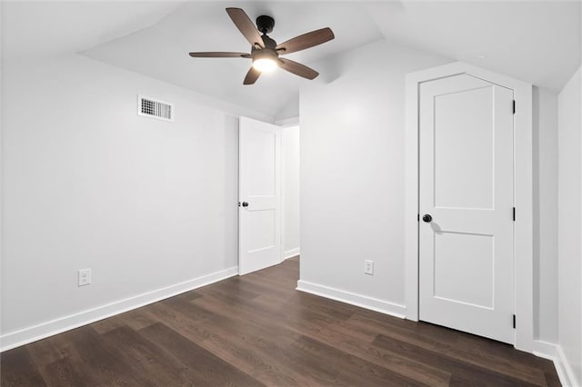 unfurnished bedroom featuring baseboards, visible vents, lofted ceiling, ceiling fan, and dark wood-type flooring