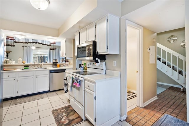 kitchen featuring white cabinets, light tile floors, and stainless steel appliances