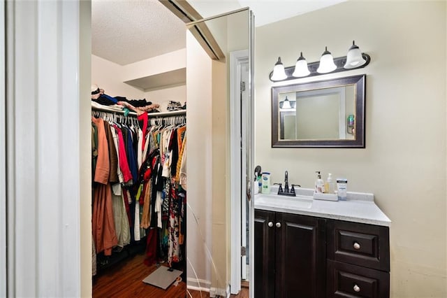 bathroom featuring hardwood / wood-style floors, a textured ceiling, and vanity