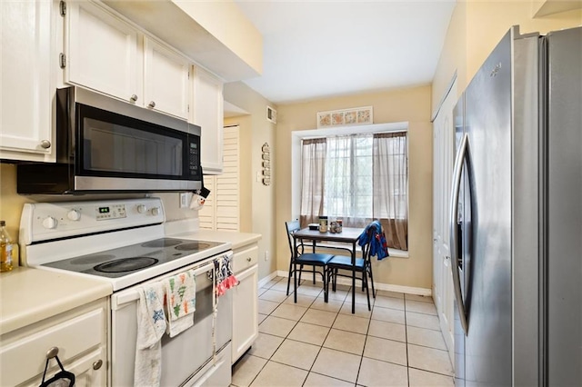 kitchen with stainless steel appliances, white cabinets, and light tile floors