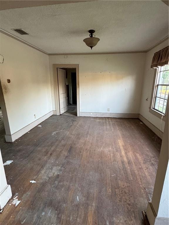 unfurnished room featuring a textured ceiling, dark hardwood / wood-style flooring, and ornamental molding