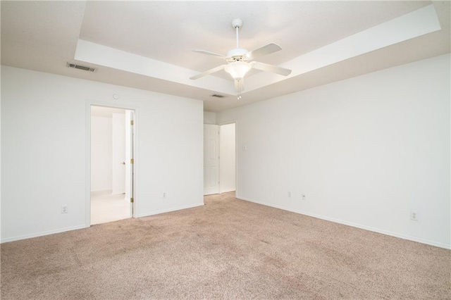 unfurnished room featuring light colored carpet, ceiling fan, visible vents, and baseboards