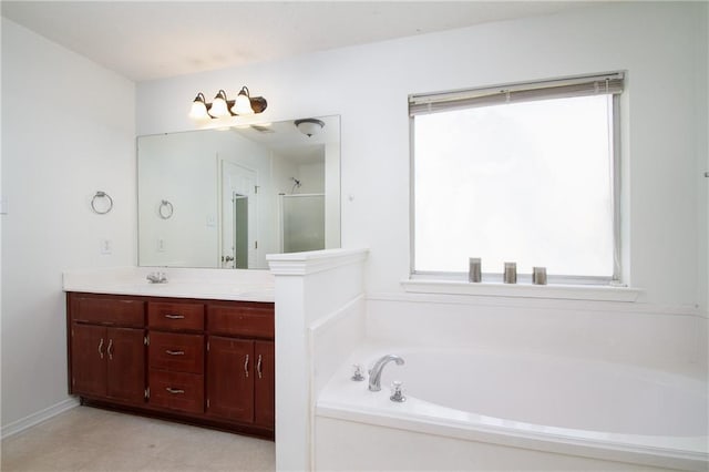 bathroom with double vanity, a shower with door, a garden tub, and a sink